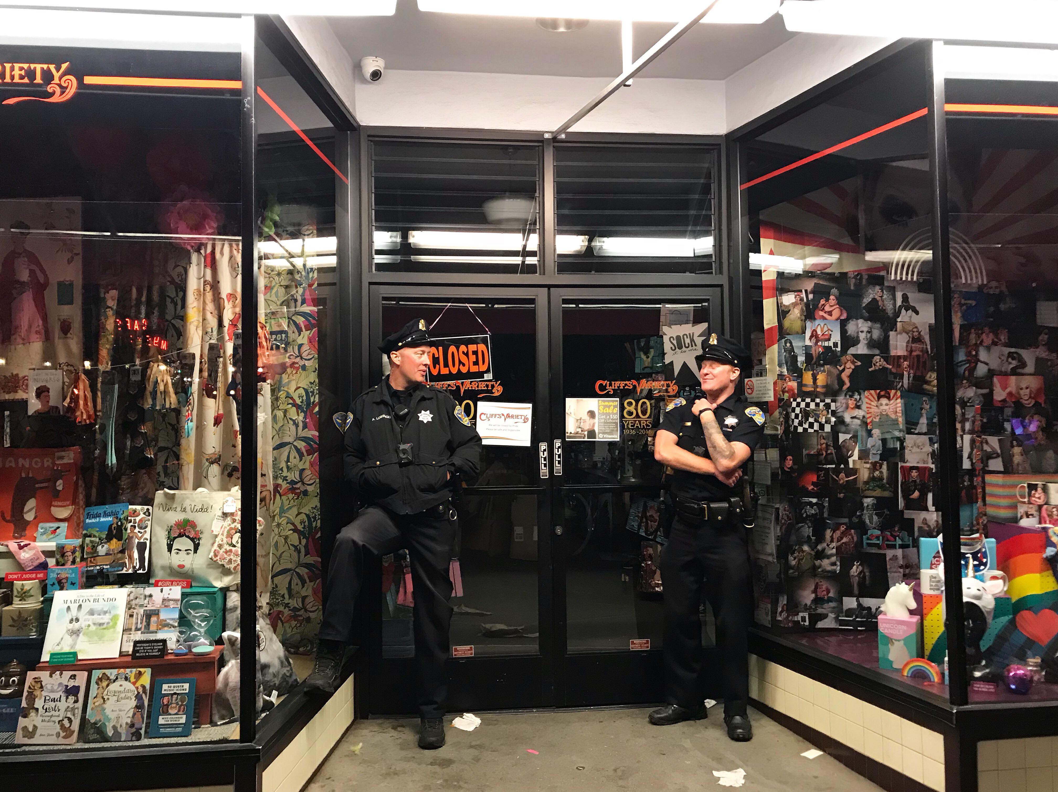 Candid photograph of two police officers standing in front of a shopfront in San Francisco circa 2018.